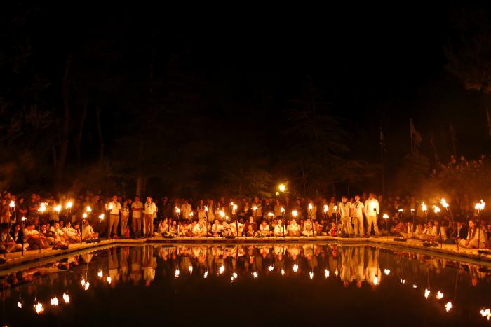 Israeli youth Scouts are reflected in a pool as they light torches, during a memorial ceremony at the Mount Herzl military cemetery, on the eve of Memorial Day in Jerusalem, Israel, 10 May 2016. (Credit: EPA)