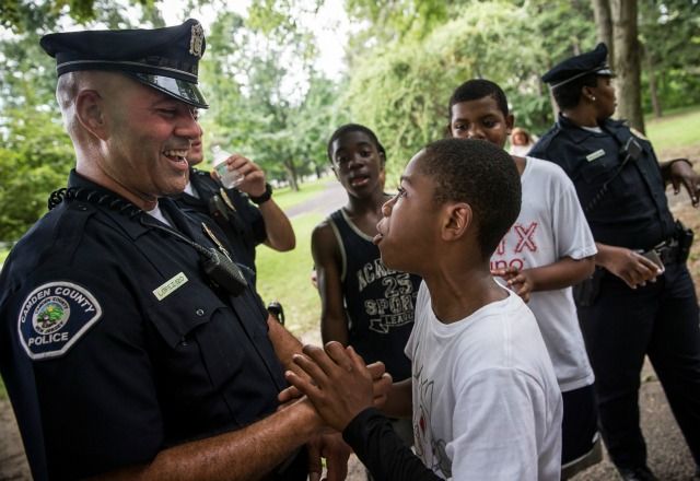 A Camden, New Jersey, police officer talks with a neighborhood child. (Photo: Andrew Burton/Getty Images)